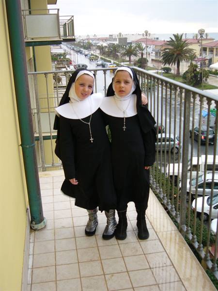 Children dressed as nuns with crucifixes on a Viareggio balcony