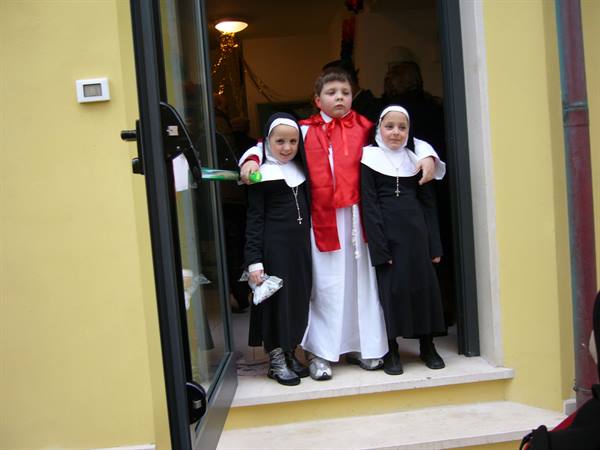 Children dressed as nuns and priest on a doorway in Viareggio