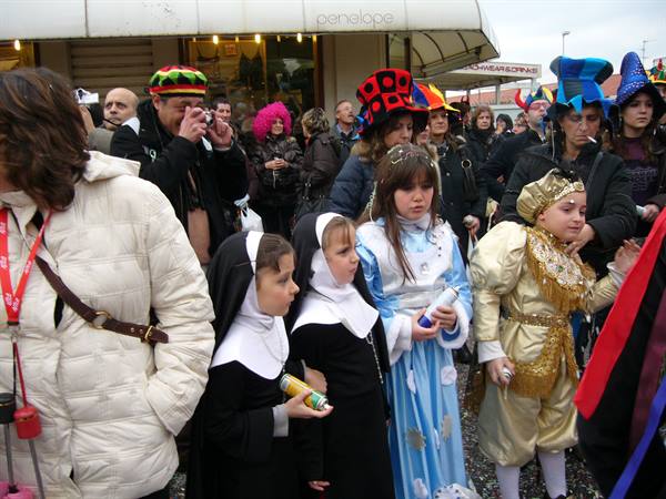 Children dressed as nuns and princesses in the Viareggio carnival crowd