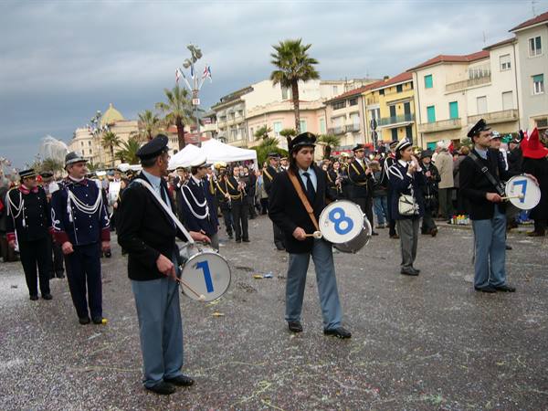 Uniformed drummers with numbered drums marching on Viareggio seafront