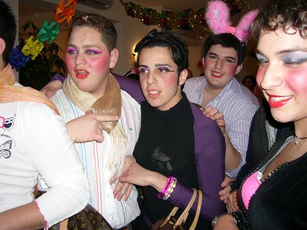 Young people in makeup celebrating carnival in Viareggio, colorful decorations, indoor lighting
