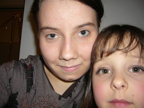 Young woman and girl look at the camera indoors, home lighting