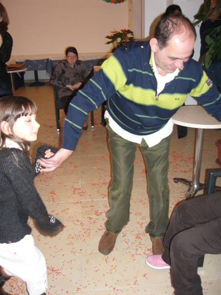 Man dances with a little girl among confetti in a Viareggio party hall