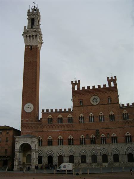 Torre del Mangia and brick Palazzo Pubblico on Piazza del Campo, Siena, grey sky