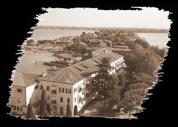 Sepia lakeside hotel on Lake Garda, tiled roofs and beach below