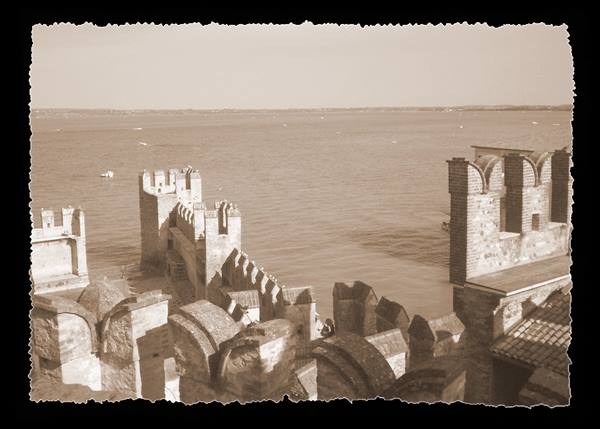 Stone battlements and towers of Sirmione's Scaligero Castle overlooking Lake Garda