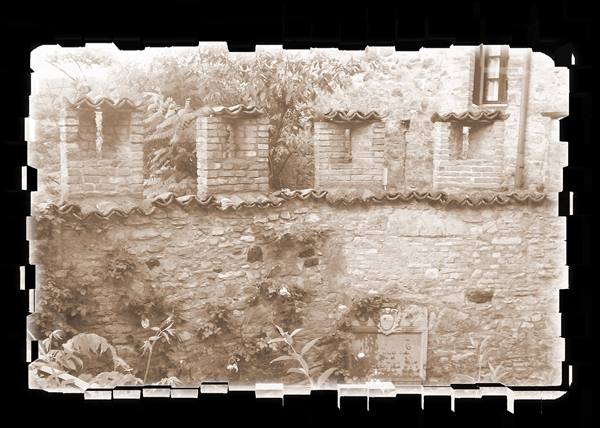 Stone wall topped with brick merlons and tiles, old sepia photograph