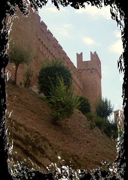 Red brick ramparts with swallowtail battlements above the hillside, Gradara
