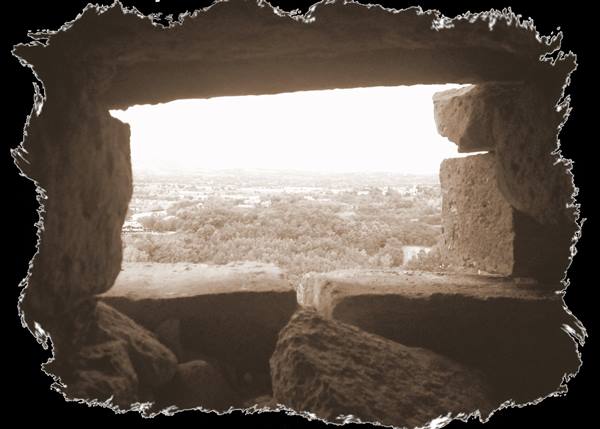 Squared stone block frames the sunlit countryside, sepia tones
