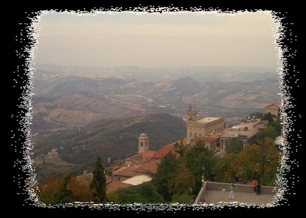 San Marino's Palazzo Pubblico towers over rooftops above misty hills