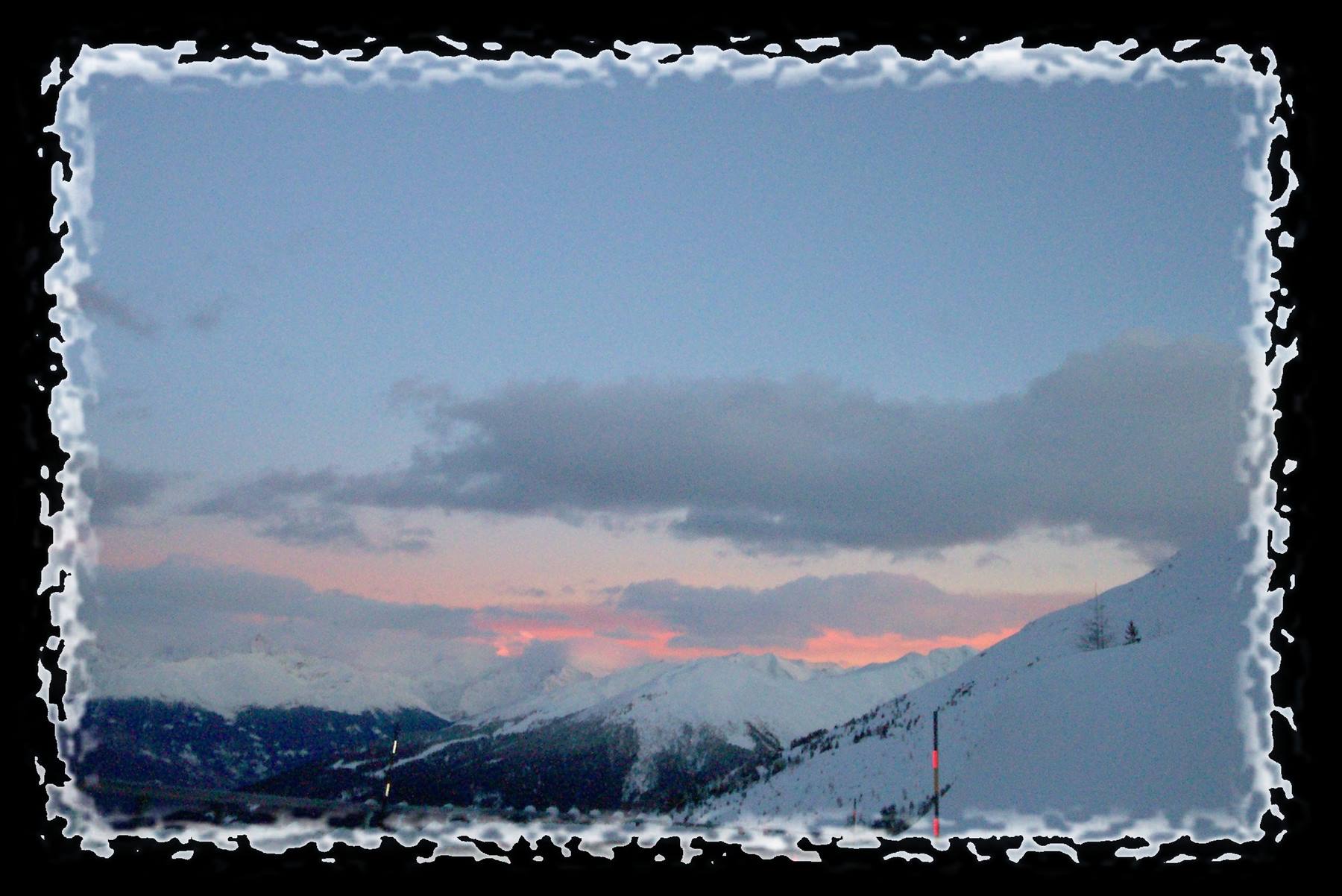 Snowy peaks glowing under pink evening sky