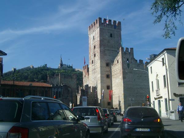 Traffic passing the crenellated walls of Castelvecchio, Verona
