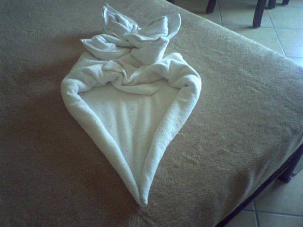 White towel folded into a heart shape on the hotel bed