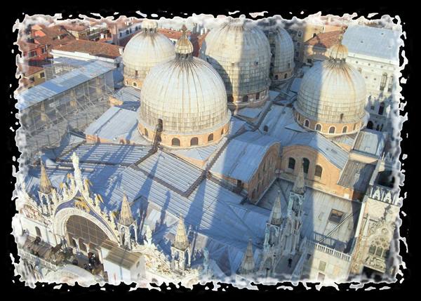 The lead domes of St Mark's Basilica in Venice with the bell tower's shadow