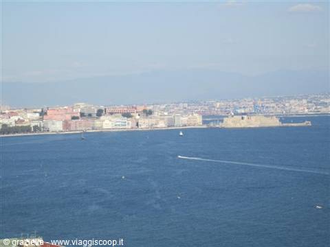 Blue sea with speeding boat in front of the city and sea fort