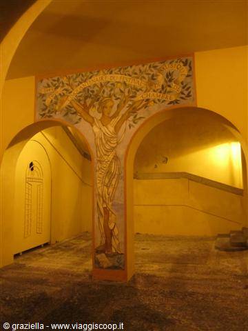Woman fresco between yellow arches in a vaulted interior with warm light