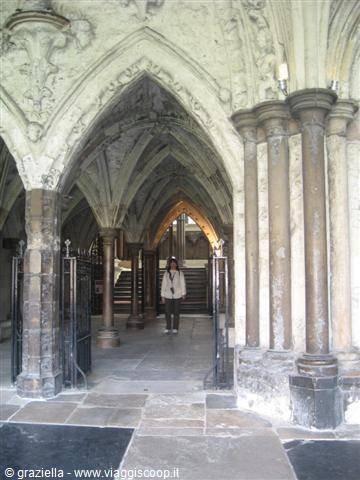 Woman walking among Gothic columns in Westminster Abbey's cloister