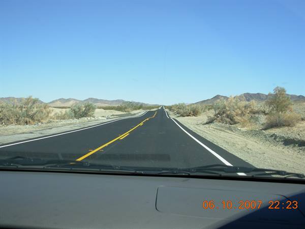 Desert highway with yellow lines seen from car dashboard