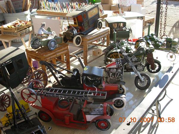 Vintage tin toys: motorcycles, cars and trucks displayed in sunlight on a table