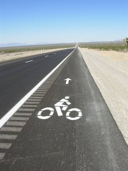 Painted bike lane on asphalt along a desert highway