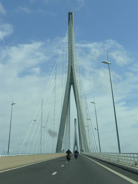 Two motorcycles crossing the Pont de Normandie, concrete pylon with steel cables