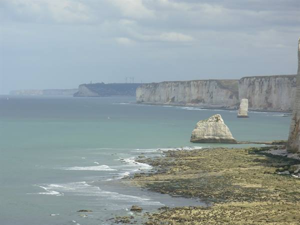 Étretat cliffs, white chalk stacks over the sea with rocky shore below