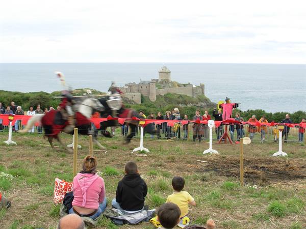 Knights jousting before spectators at Fort-la-Latte by the sea