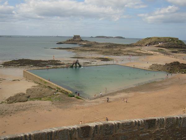 Seawater pool in Saint-Malo at low tide, swimmers on the sandy beach