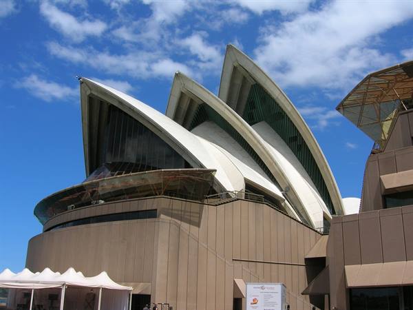 The white sails of Sydney Opera House under a blue sky with clouds