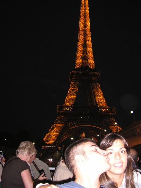 Kissing couple in front of the illuminated Eiffel Tower at night