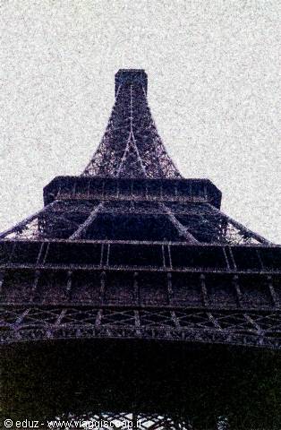Eiffel Tower iron lattice shot from below against grey sky