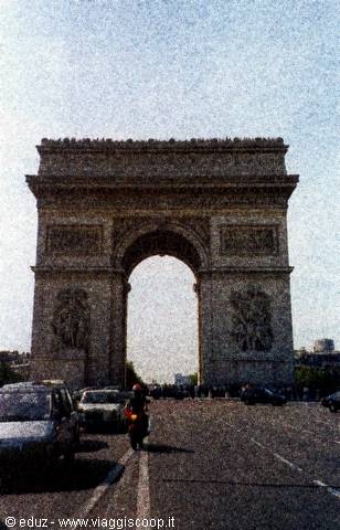 Arc de Triomphe in Paris, traffic and scooter passing beneath daylight