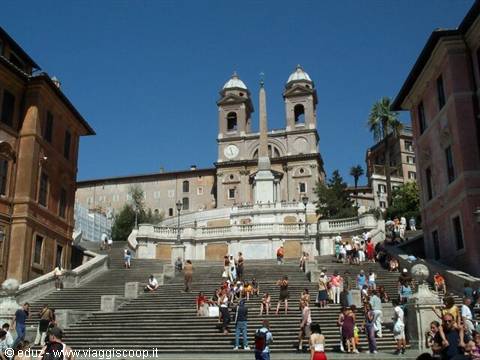 Tourists on the Spanish Steps with Trinità dei Monti church under blue sky