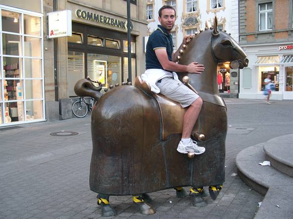 Tourist riding the bronze horse sculpture on a square in Konstanz