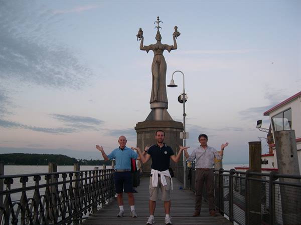 Three men mimic the Imperia statue on Konstanz harbor pier