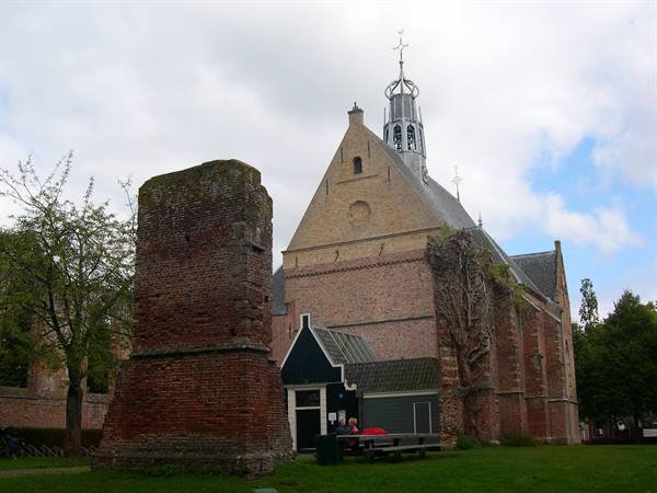 Bergen church with red brick ruin and tower, under cloudy sky