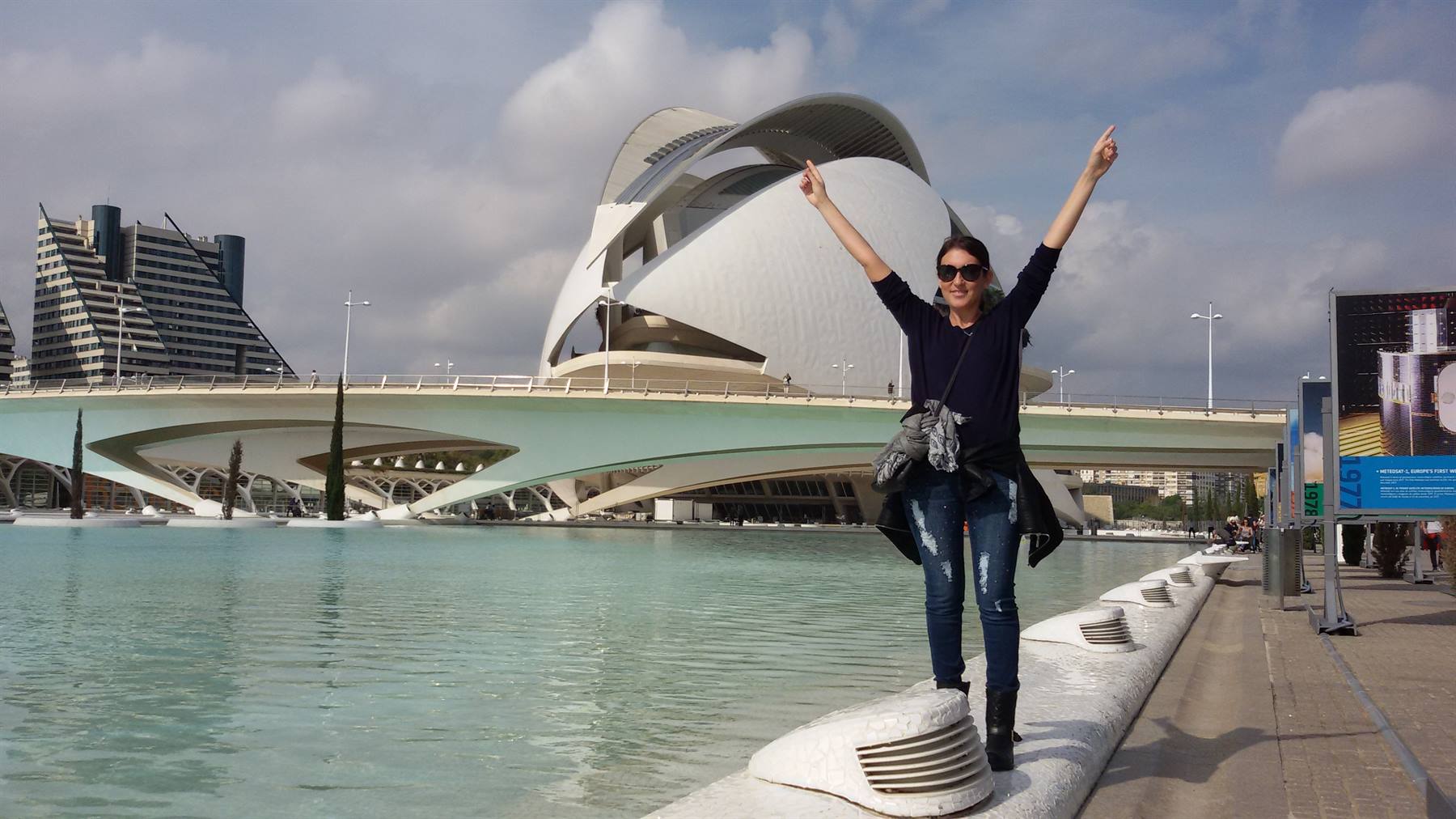 Donna con braccia alzate davanti alla Ciutat de les Arts i Ciències di València