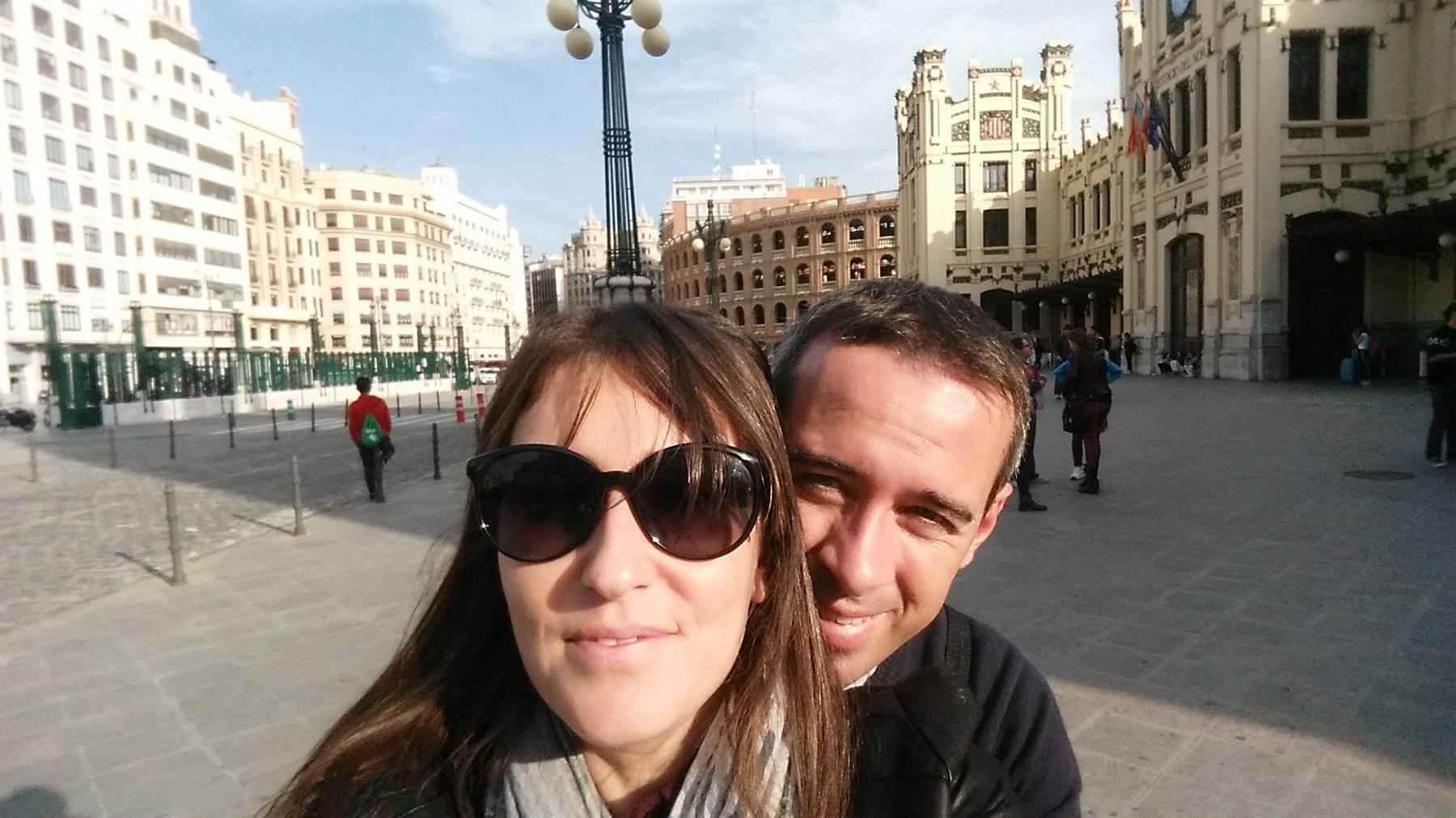 Selfie di coppia davanti a Piazza del Municipio a Valencia, edifici liberty e luce solare