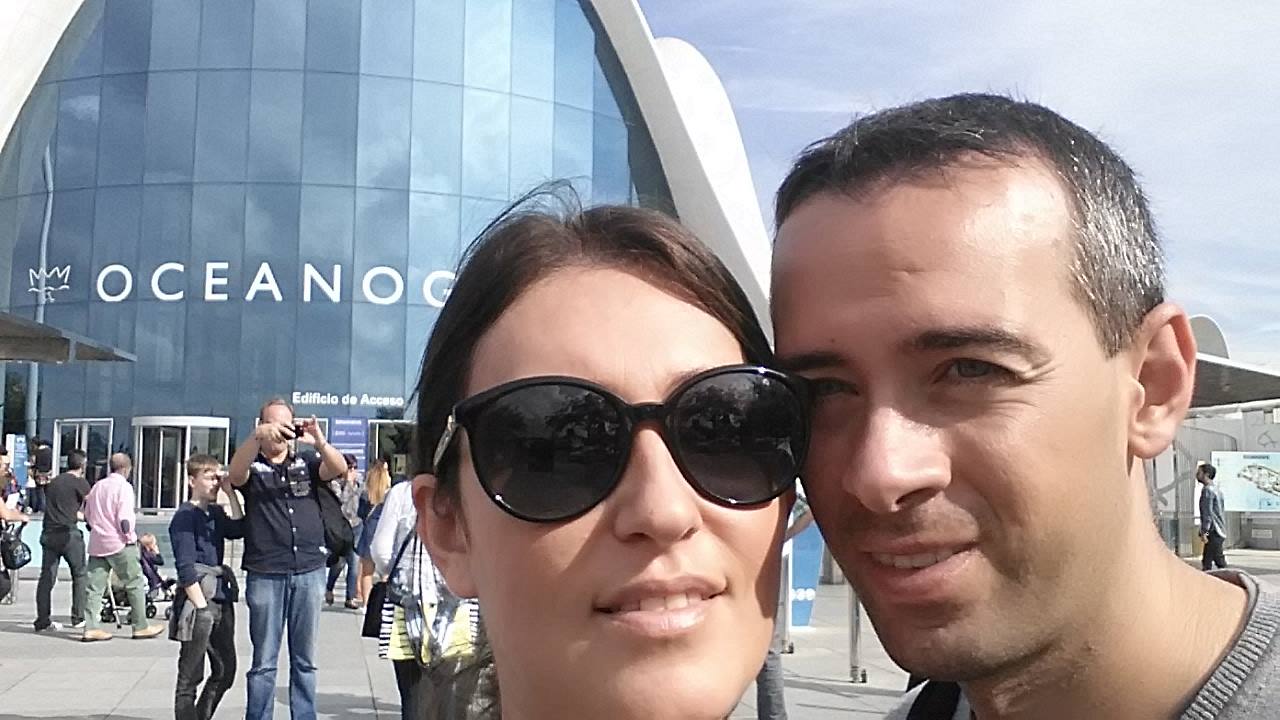 Selfie davanti all'Oceanogràfic di Valencia, facciata curva di vetro blu, turisti intorno