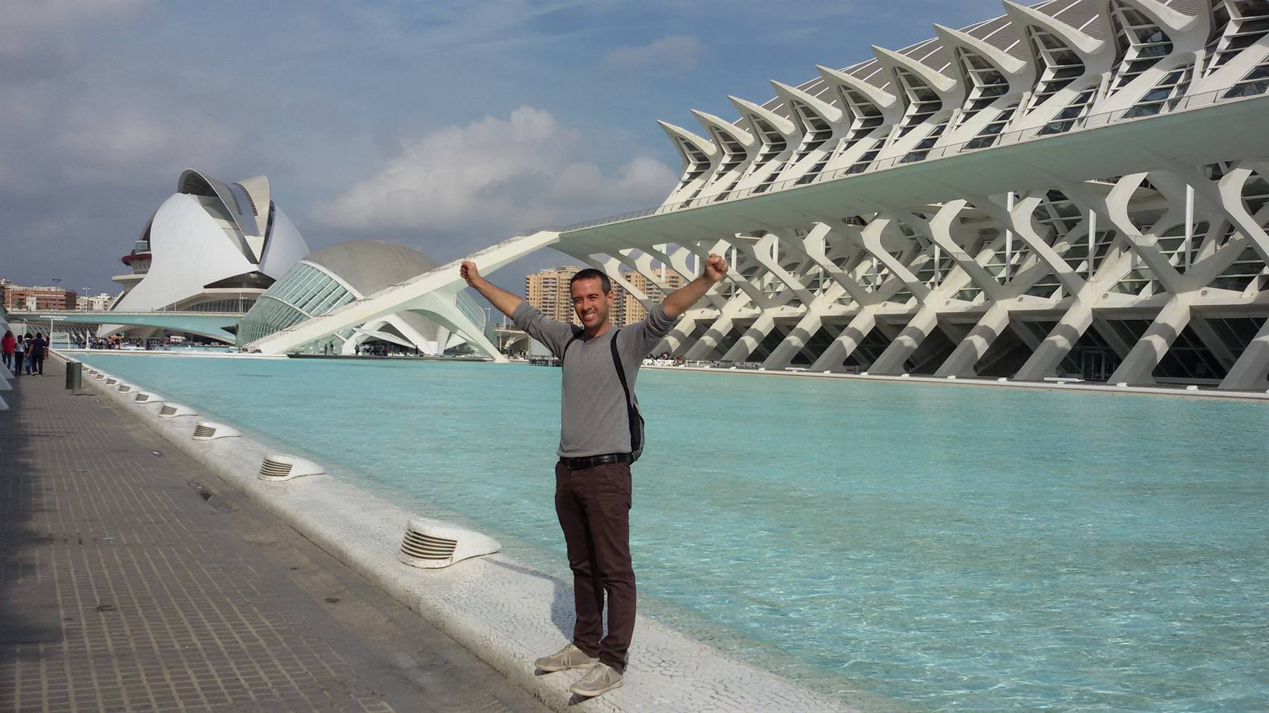 Uomo con braccia alzate accanto alla piscina della Città delle Arti e delle Scienze, Valencia