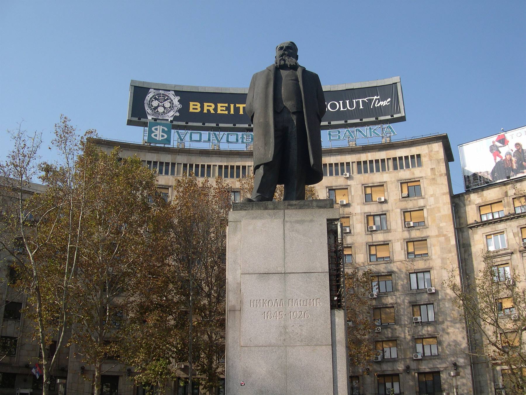 Statua di Nikola Pašic su piedistallo in pietra davanti al palazzo della Vojvodanska banka