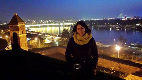 Woman in yellow scarf at night in Kalemegdan, Sava river illuminated