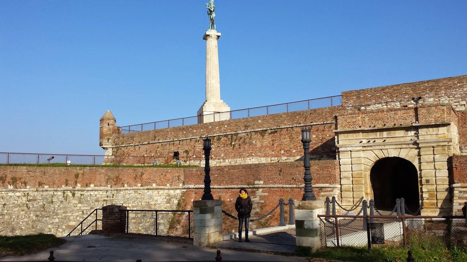 Turista sotto la statua del Vincitore sulla fortezza di Kalemegdan, Belgrado