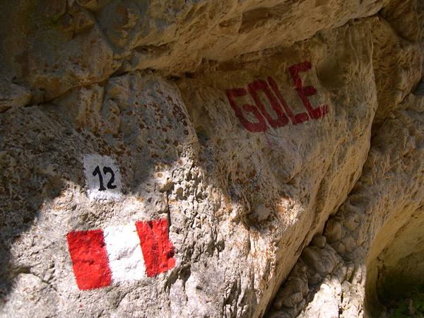 Red and white trail marker number 12 painted on limestone rock, Gole inscription