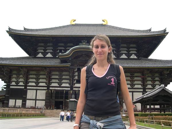 Tourist in front of Tōdai-ji Temple in Nara, dark wood under soft daylight