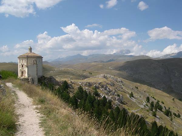 Octagonal church of Santa Maria della Pietà above Rocca Calascio, trail through grass and rocks