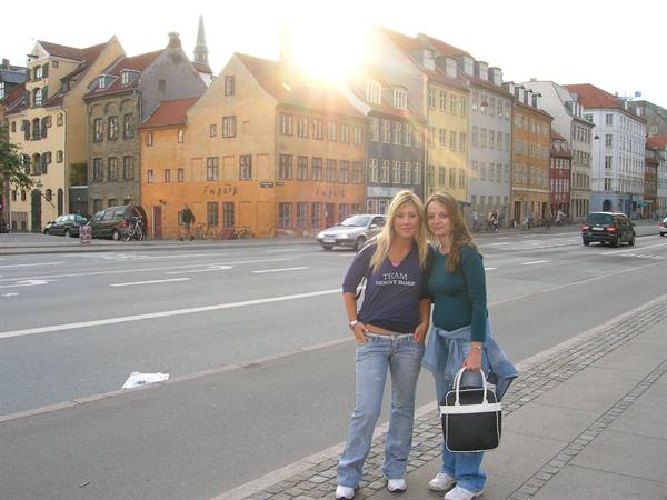 Two girls on a street in Copenhagen, colorful houses and low sun behind