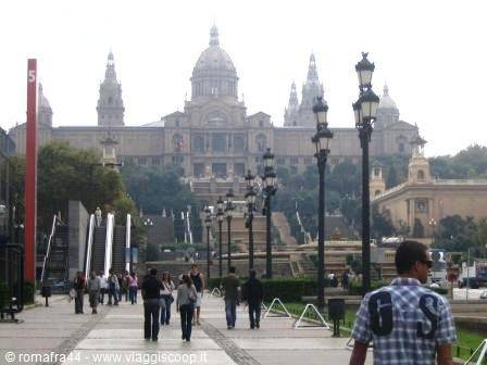 Tourists walk toward the National Art Museum of Catalonia in Barcelona