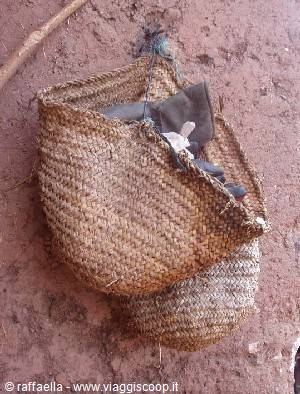 Woven straw baskets hanging on a red mud wall