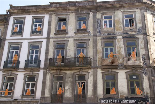 Weathered facade with orange figures at windows, Hospedaria Mouzinho sign